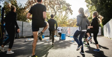 gruppe_sportlicher_junger_menschen_im_gegenlicht_mit_trainer