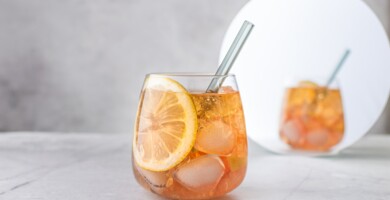 Ein orangenes alkoholisches Getränk welches vor einem Spiegel steht auf einer Marmorplatte