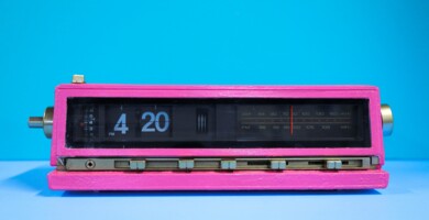 Pinker Wecker auf dem die Uhrzeit 4:20 angezeigt wird vor blauem Hinter