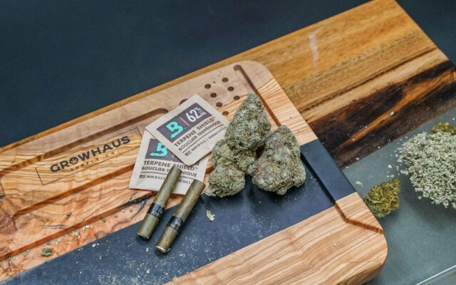Diverses Zubehör für den Cannabiskonsum auf Holzbrett
