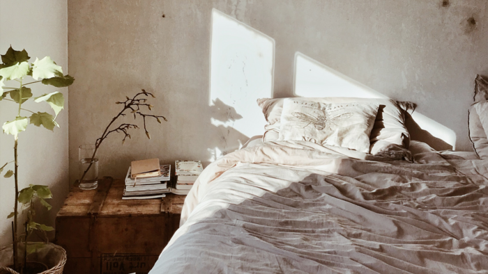Gemütliches Zimmer in dem ein Bett steht und die Sonne durch das Fenster scheint