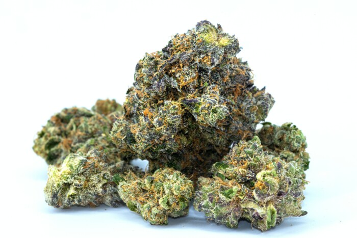 Mehrere Cannabisblüten welche auf einem weißen Untergrund vor einem weißen Hintergrund liegen