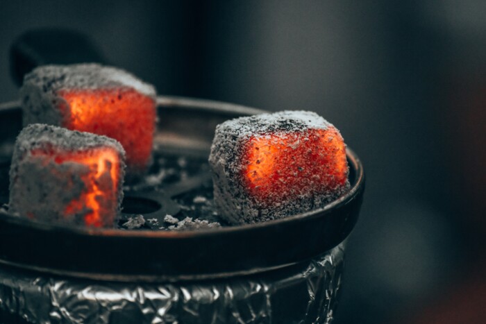 Drei glühende Kohlen welche auf dem Kopf einer Wasserpfeife liegen