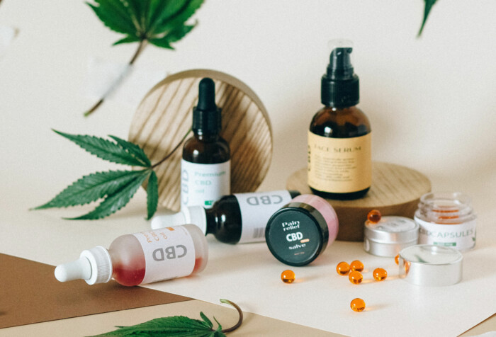 Verschiedene Cannabisprodukte die auf einem Tisch liegen mit Cannabisblättern