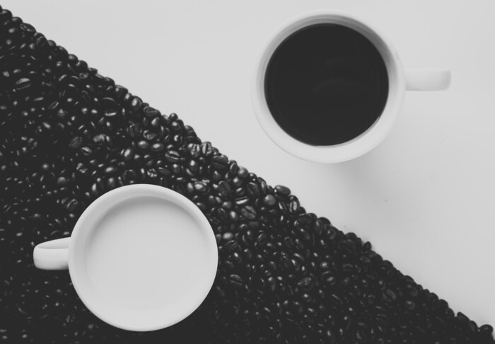 Zwei Tassen welche Milch und Kaffee im Stile von Yin und Yang symbolisieren