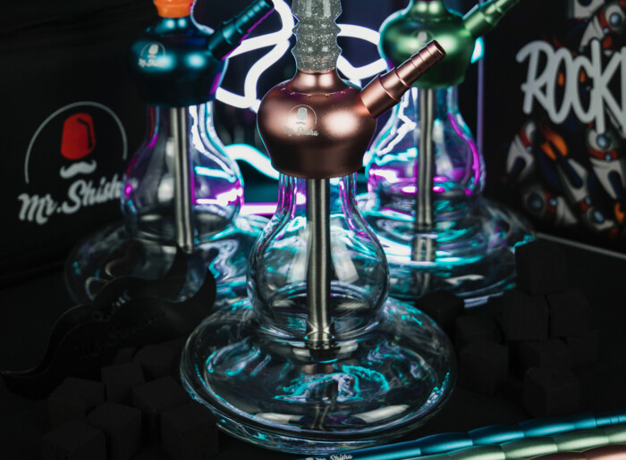 Detailaufnahme des Wasserkörpers einer Wasserpfeife mit Neonbeleuchtung im Hintergrund