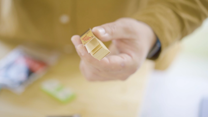 Hand die eine Packung Filtertips in die Kamera hält
