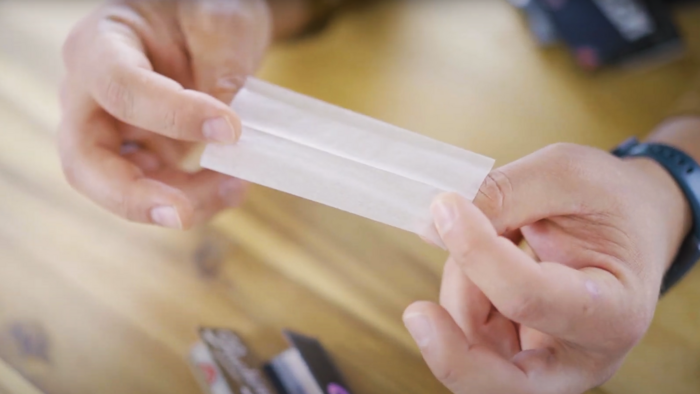 Zwei Hände die ein Joint Longpaper in die Kamera halten