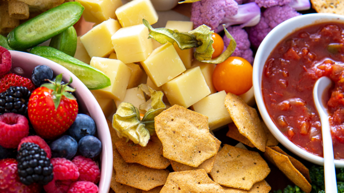 Bunte Platte mit frischem Obst, Käse und einem Dip