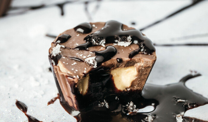 Peanut Buttercups mit Schokoladensoße auf einer weißer Platte