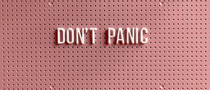 Pinke Pinnwand auf welcher die Wörter Don´t Panic aufgepinnt sind