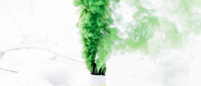 rauchdose_aus_der_gruener_rauch_aufsteigt_vor_verschwommenem_hintergrund